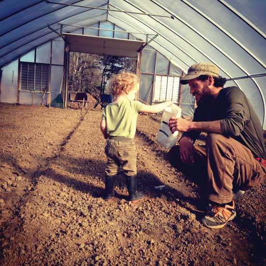 Iris helps out Dad in the hoop house.